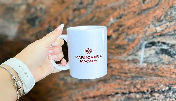 Xícara da Marmoraria Macapá, com uma Rocha (Granito) logo ao fundo.